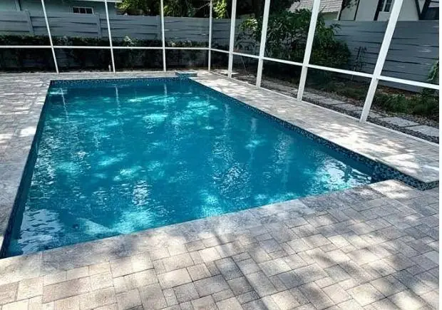 Remodeled screened pool with new glass tile and refreshed pavers