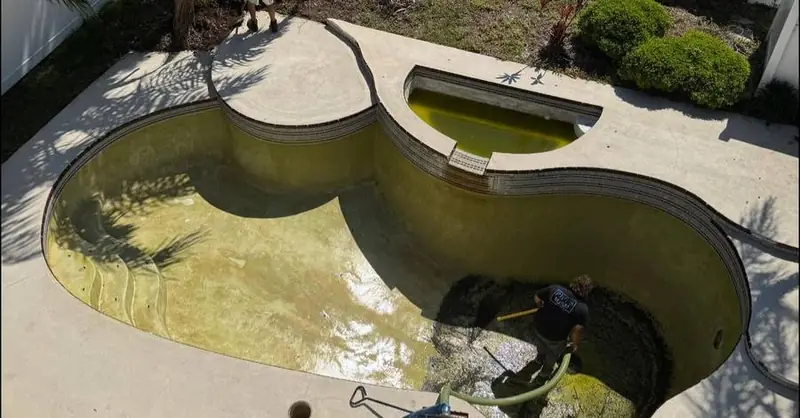 PICCS crew draining and cleaning a neglected pool